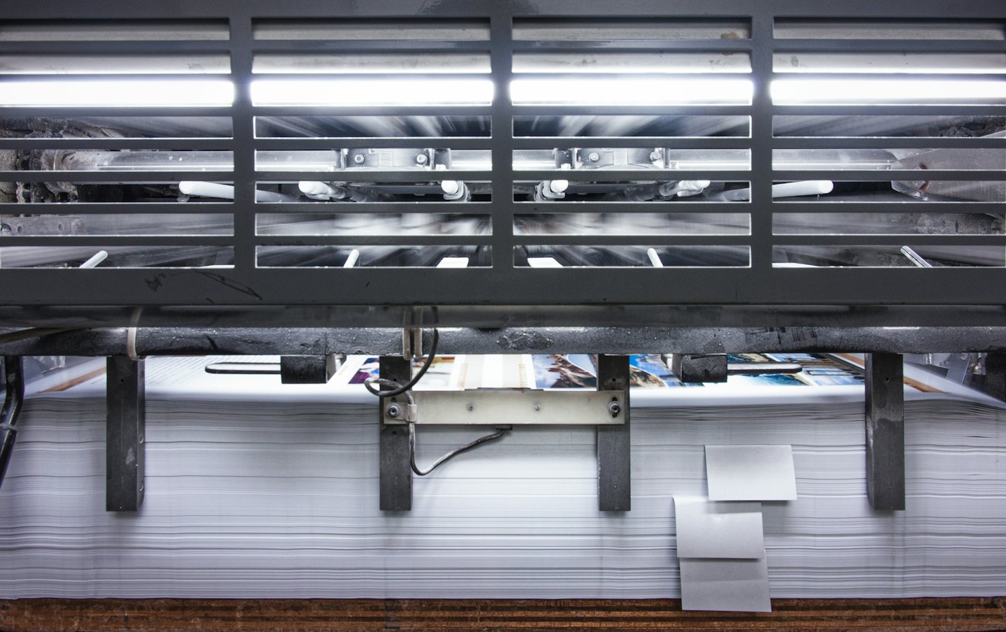 Industrial printing press operating indoors, printing paper.