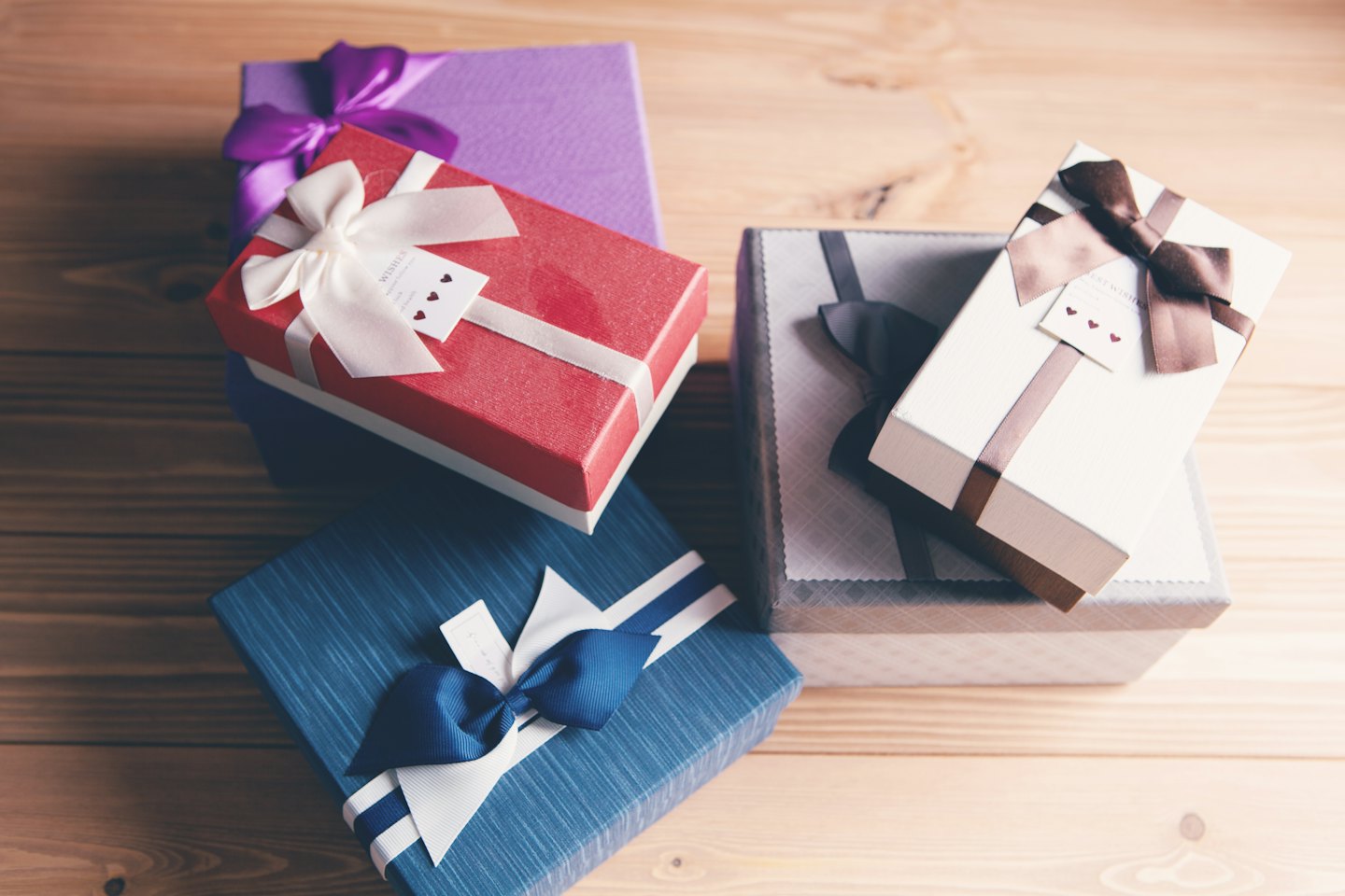 Gift boxes with bows arranged on a wooden surface.